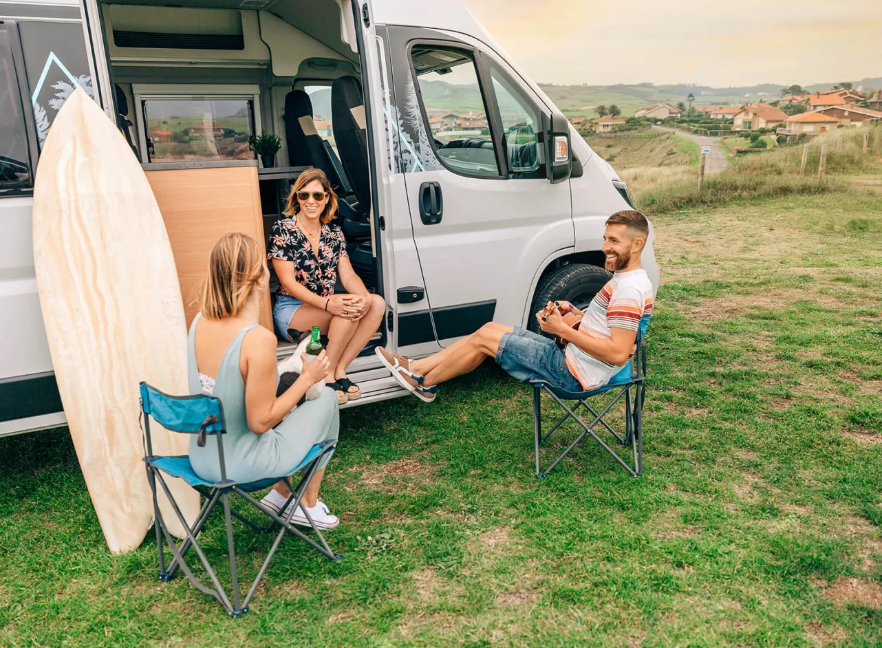 friends relaxing outside their camper 