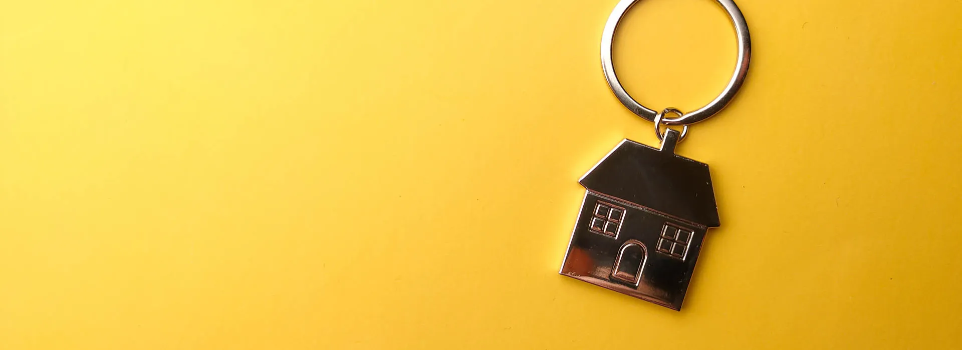 huis sleutelhanger op gele achtergrond