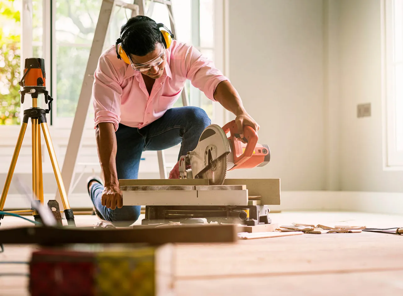 DIY man cutting floorboards 