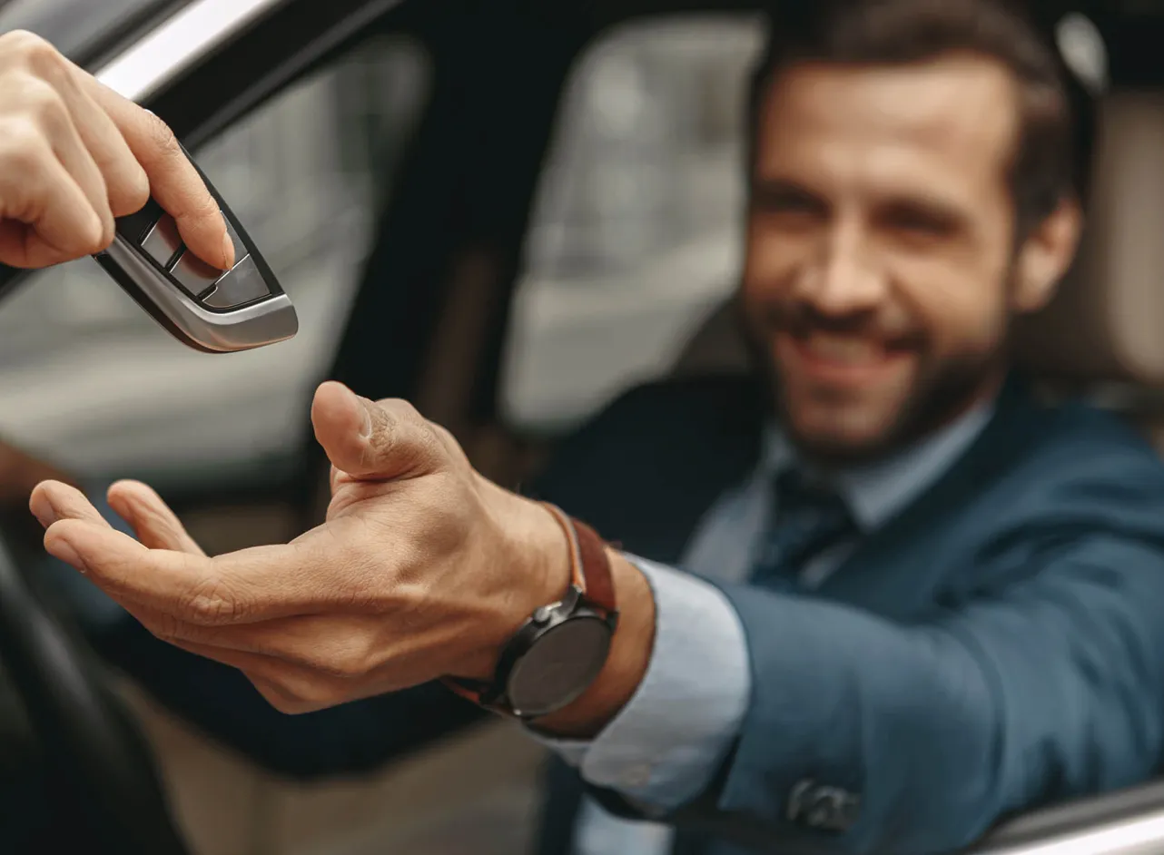 man is handed car key